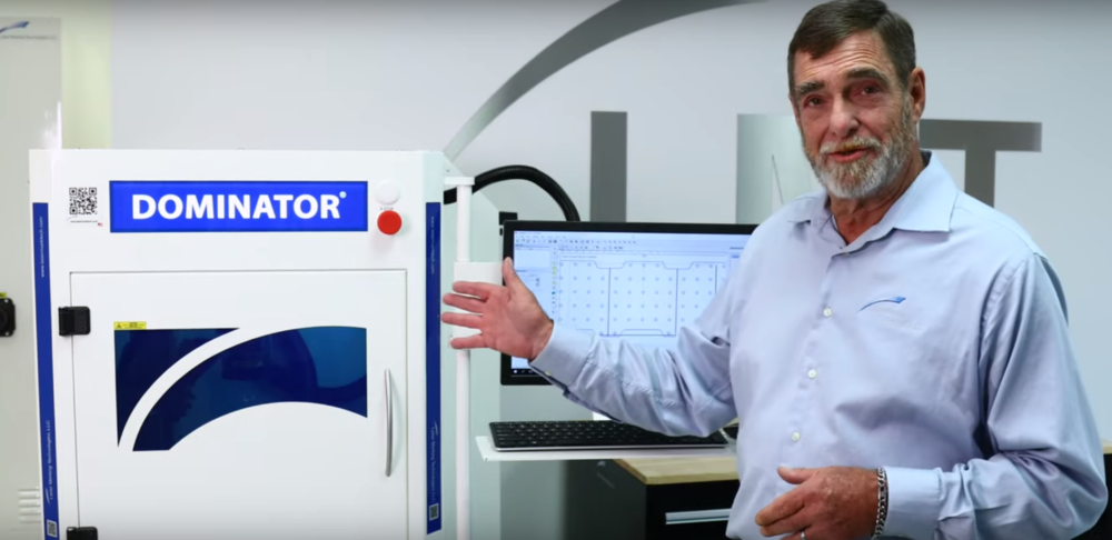 Man presenting the Dominator laser marking machine